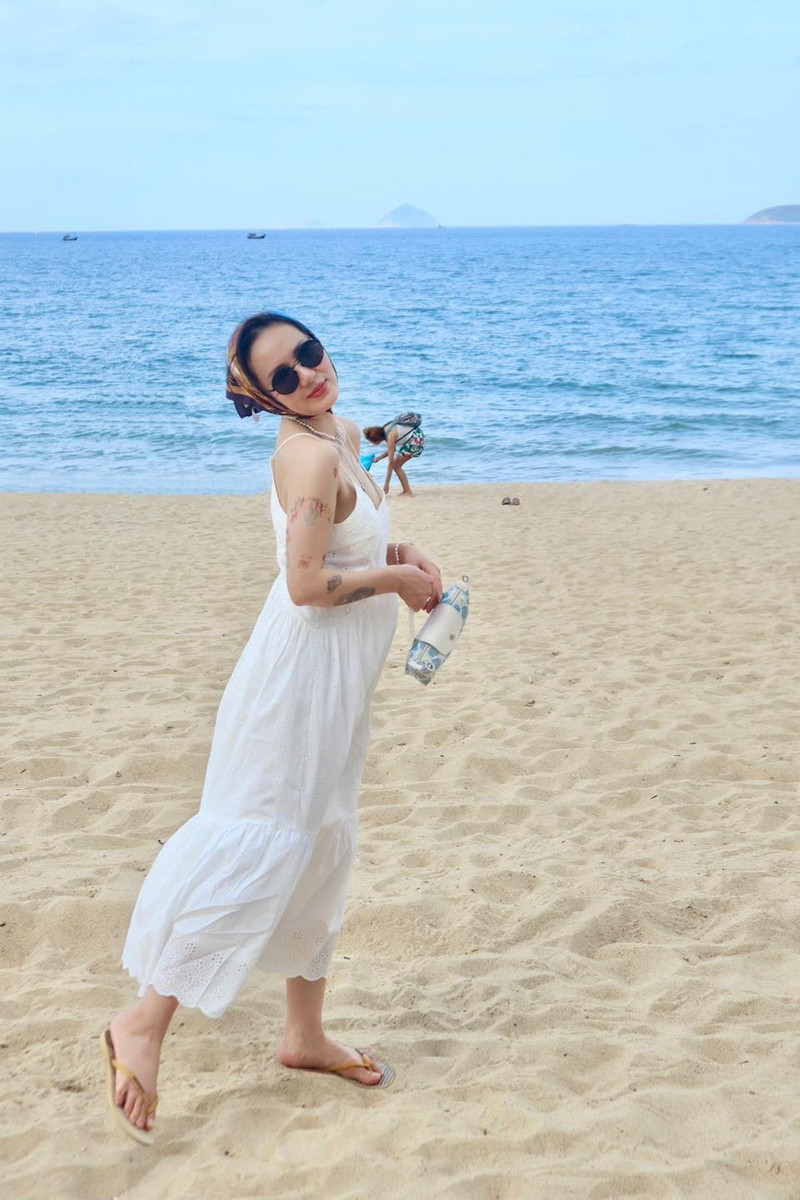 Trong khung cảnh nắng vàng biển xanh, nữ ca sĩ chọn diện váy hai dây màu trắng với chất liệu mỏng nhẹ, tôn lên bờ vai thanh mảnh, thềm ngực gợi cảm cùng vóc dáng cân đối. Ảnh: FB Tran Phuong Linh 2.jpg